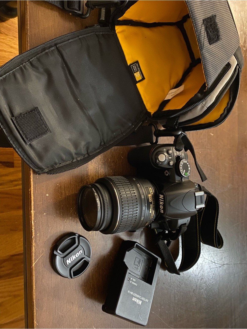 Nikon Black DSLR Camera with Zoom Lens and Black/Yellow Bag Interior